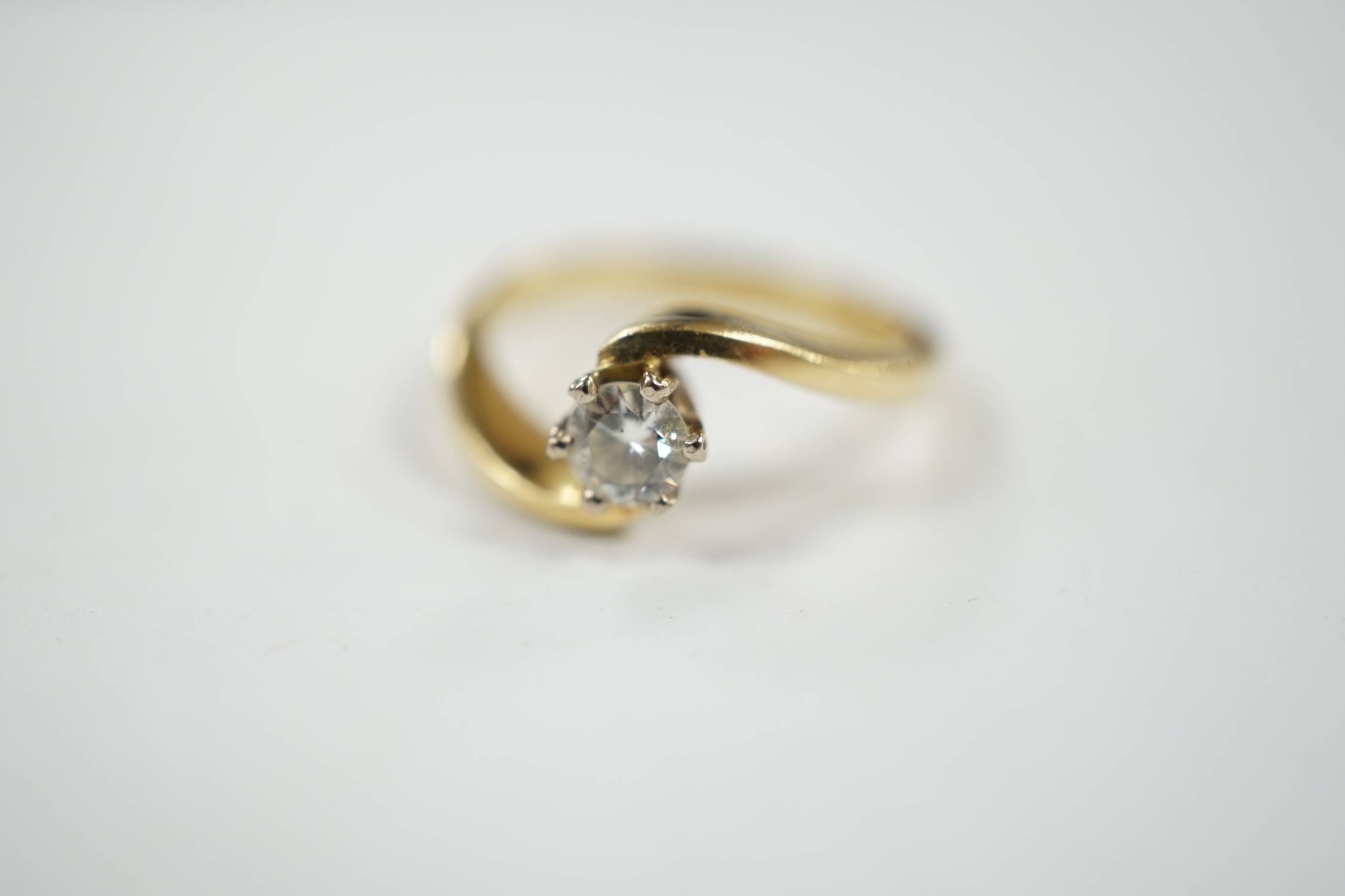 A modern 18ct gold and solitaire diamond set ring, with crossover shoulders, size K, gross weight 4 grams.